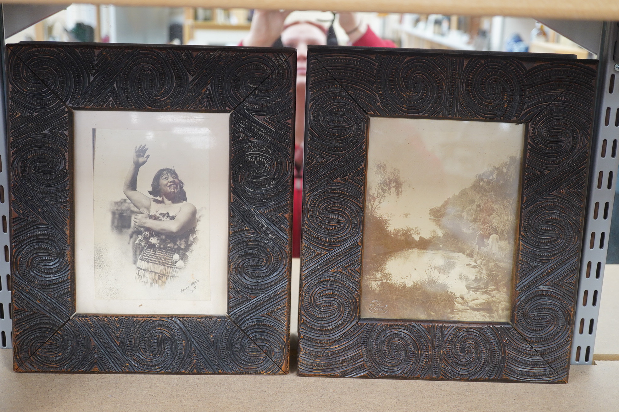 A pair of Maori carved wood photograph frames containing contemporary New Zealand photographs c.1900-10, carved in relief with rauponga lines and spirals, inset with contemporary albumen photos, depicting figures by Waik